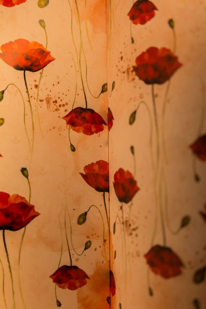 🧱 Premium Wallpapers Beautiful floral wallpaper featuring vivid red poppies and green stems on a warm background.