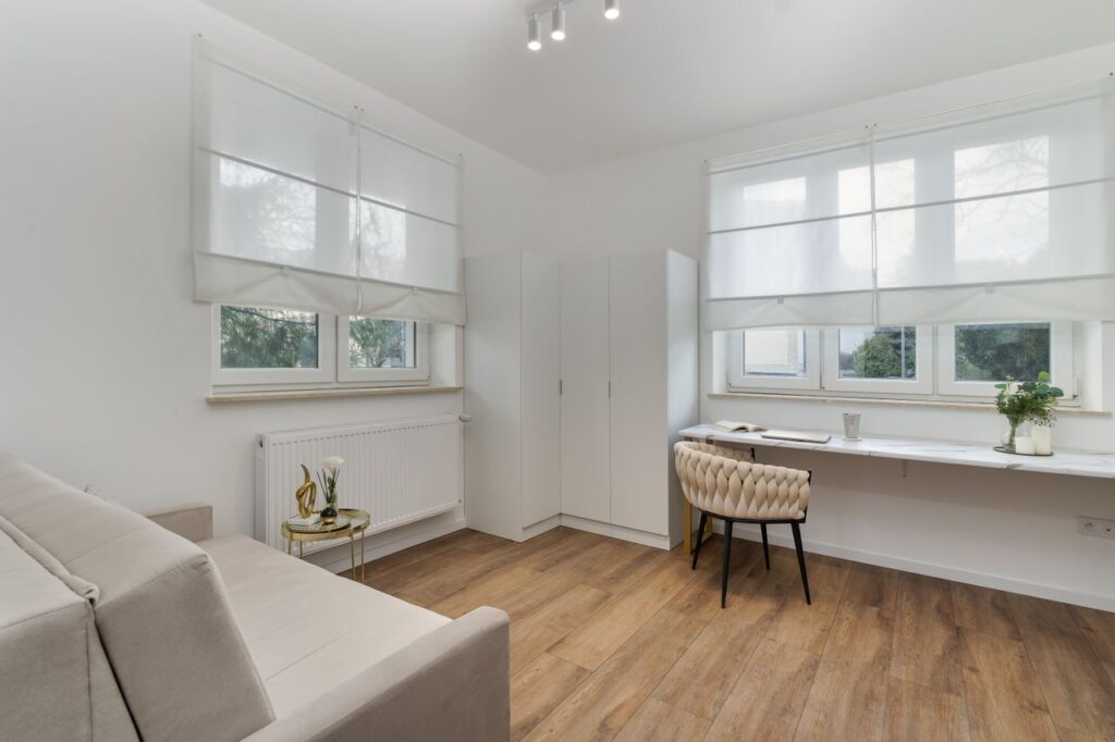 Bright and airy room with modern minimalist decor featuring wooden floors and ample natural light.