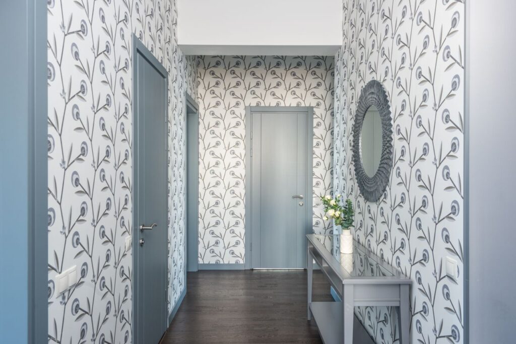 🧱 Premium Wallpapers A stylish hallway featuring floral wallpaper, a console table, and a decorative mirror.